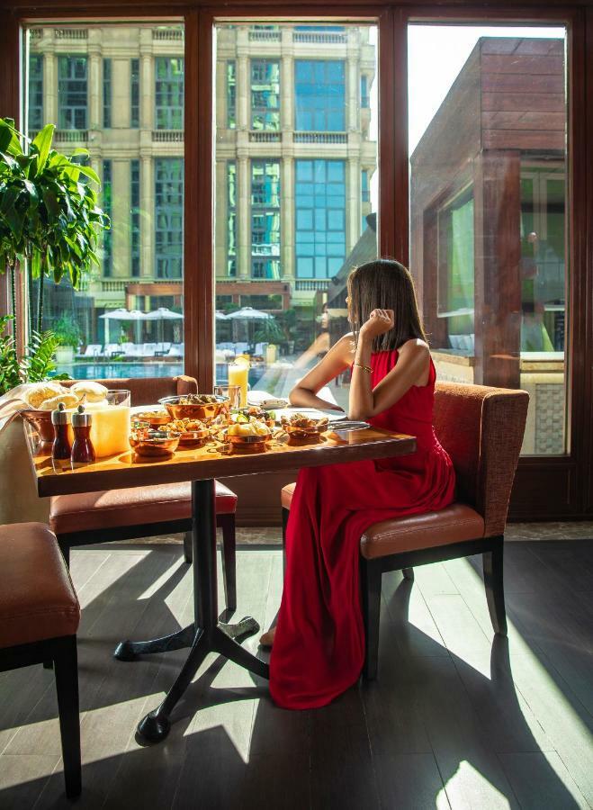 포 시즌 카이로 앳 더 퍼스트 레지던스 기자 외부 사진 A woman dining at a restaurant
